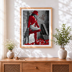 Finished woman in red hat and boots cross stitch artwork displayed