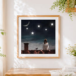Finished woman on rooftop with hanging stars cross stitch artwork displayed