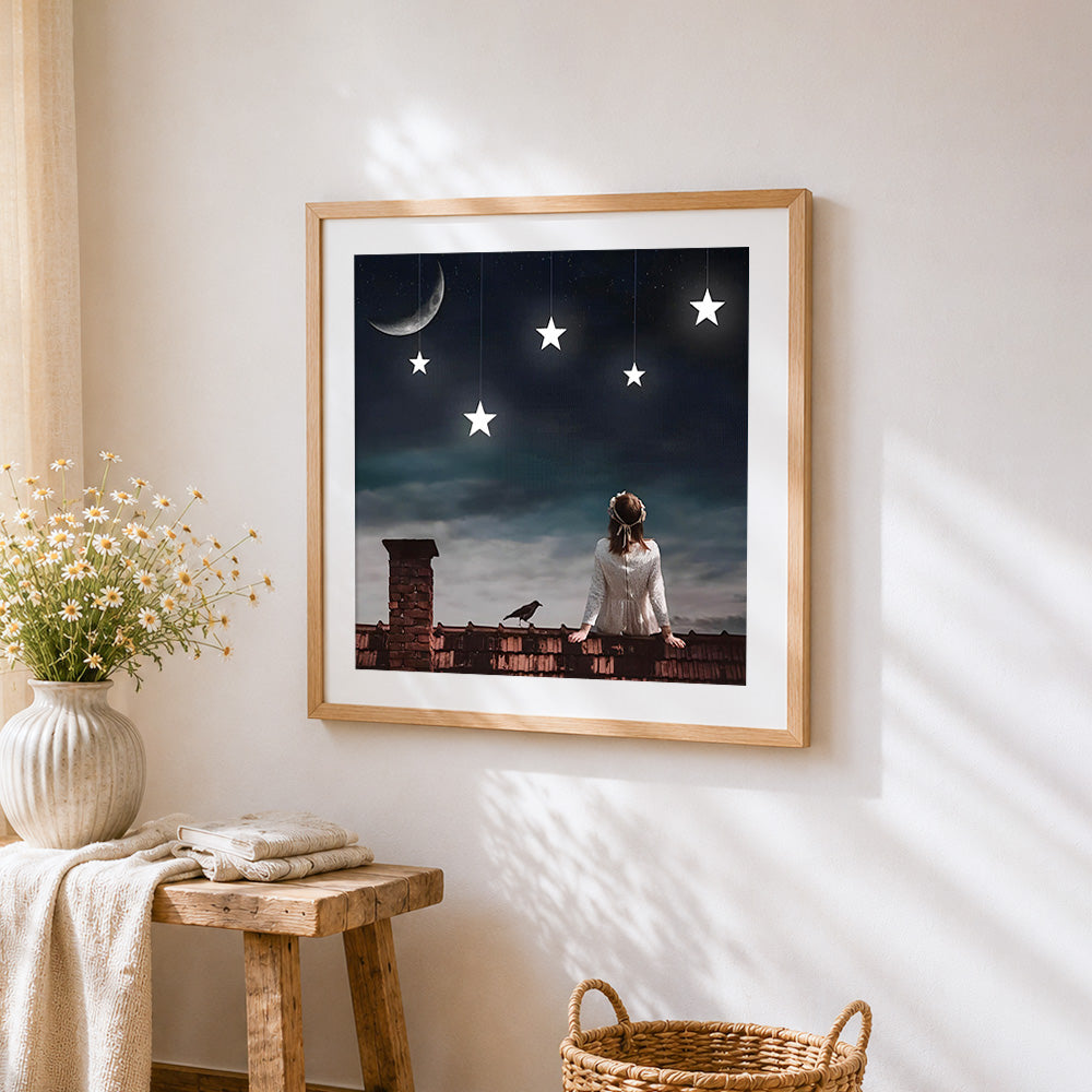 Woman on rooftop with hanging stars cross stitch artwork displayed on wall as home decor