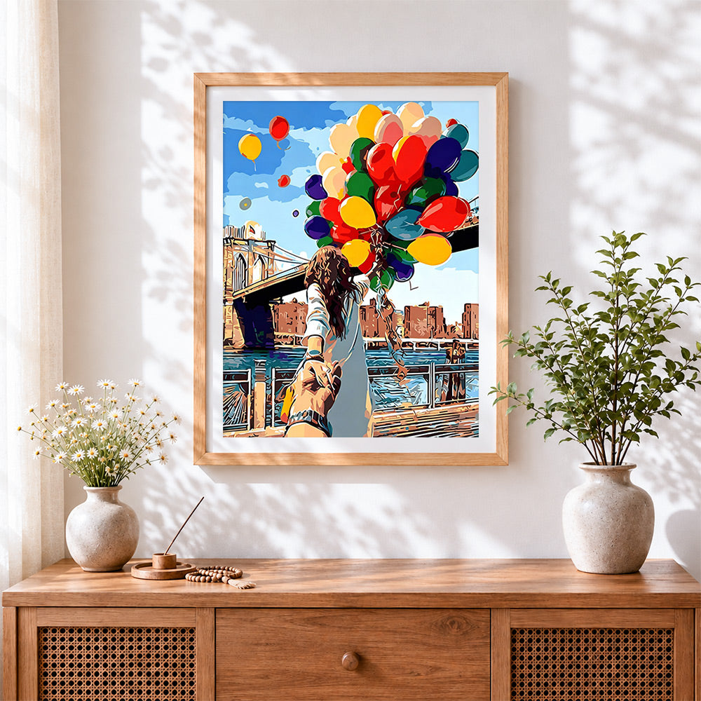 Finished woman with balloons at brooklyn bridge cross stitch artwork displayed