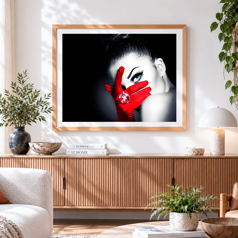 Finished woman with blue eye and red glove cross stitch artwork displayed