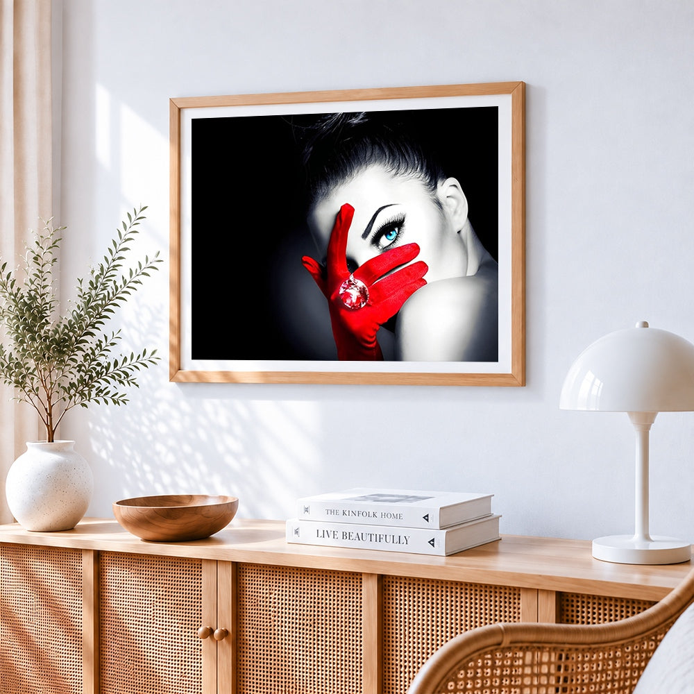Woman with blue eye and red glove cross stitch artwork displayed on wall as home decor