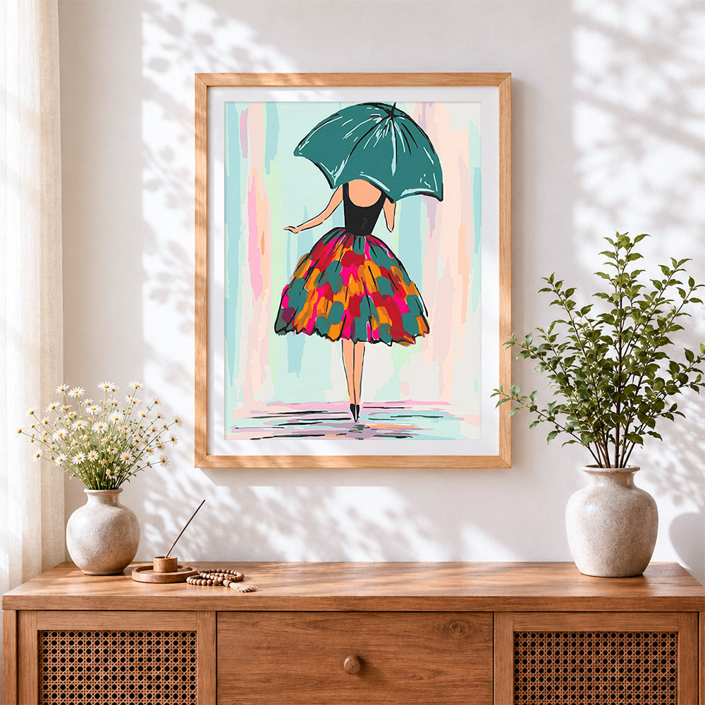 Finished woman with green umbrella and colourful skirt cross stitch artwork displayed