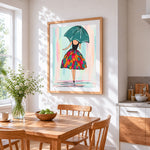Woman with green umbrella and colourful skirt cross stitch artwork displayed on wall as home decor