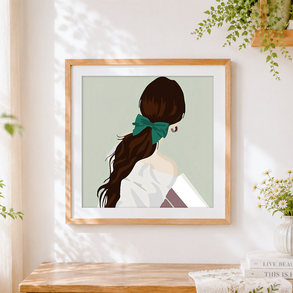 Finished woman with ponytail cross stitch artwork displayed