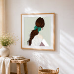 Woman with ponytail cross stitch artwork displayed on wall as home decor