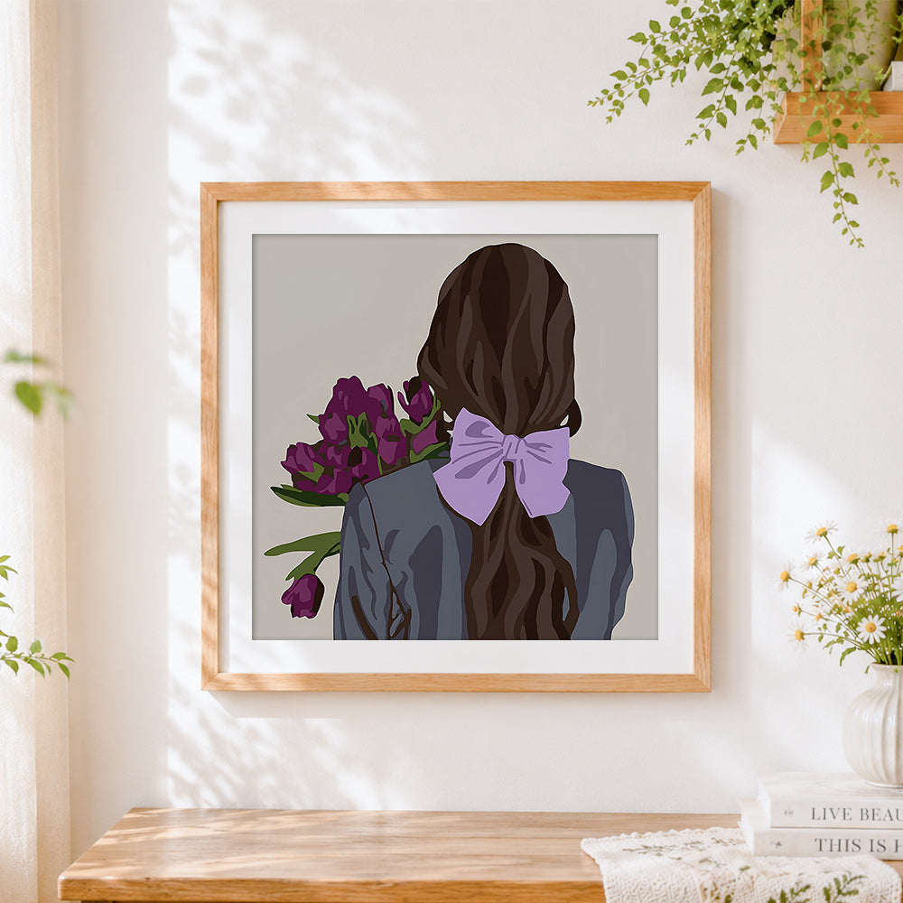 Finished woman with purple flowers and lilac bow cross stitch artwork displayed