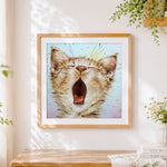 Finished yawning cat cross stitch artwork displayed
