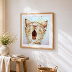 Yawning cat cross stitch artwork displayed on wall as home decor