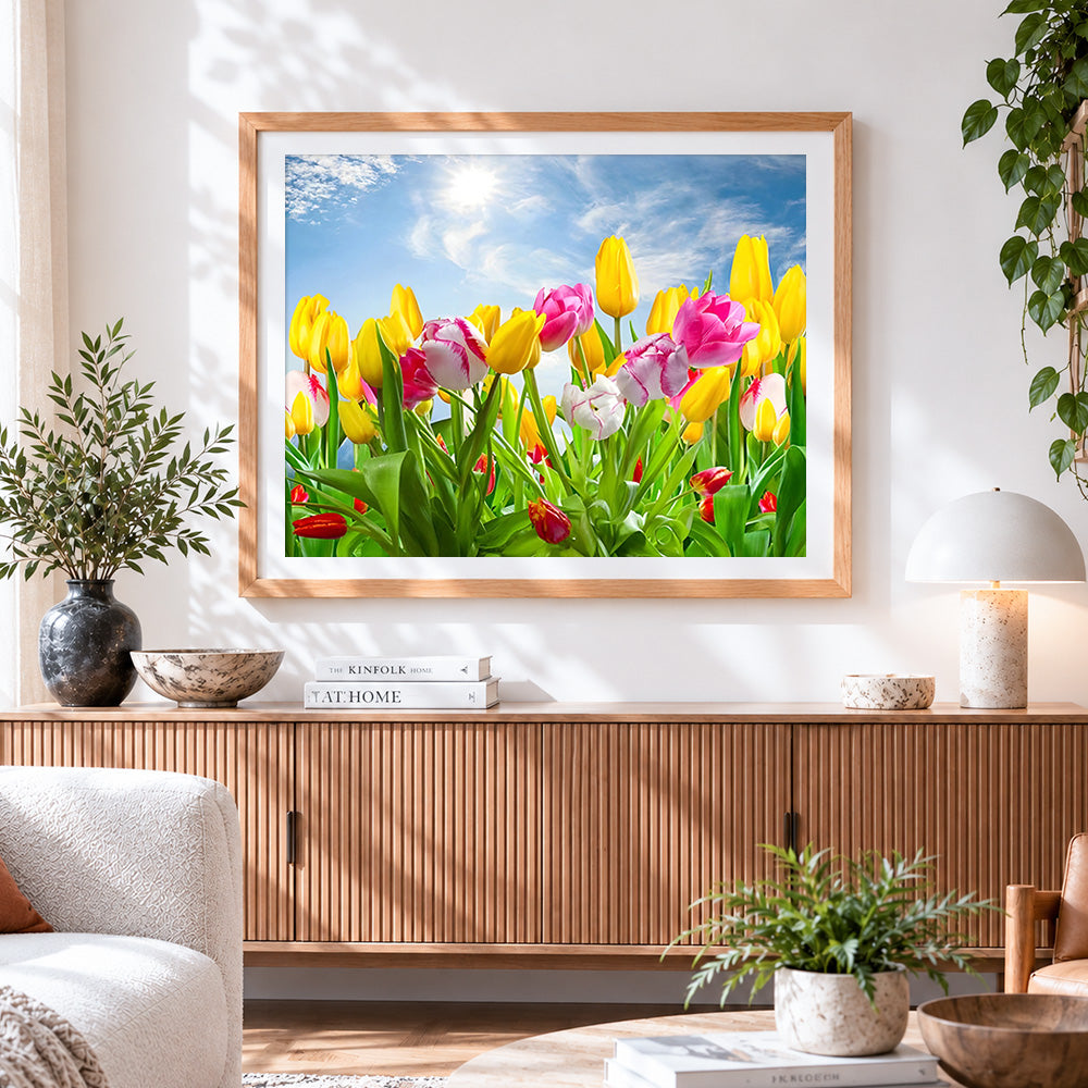 Finished yellow and pink tulips under blue sky cross stitch artwork displayed
