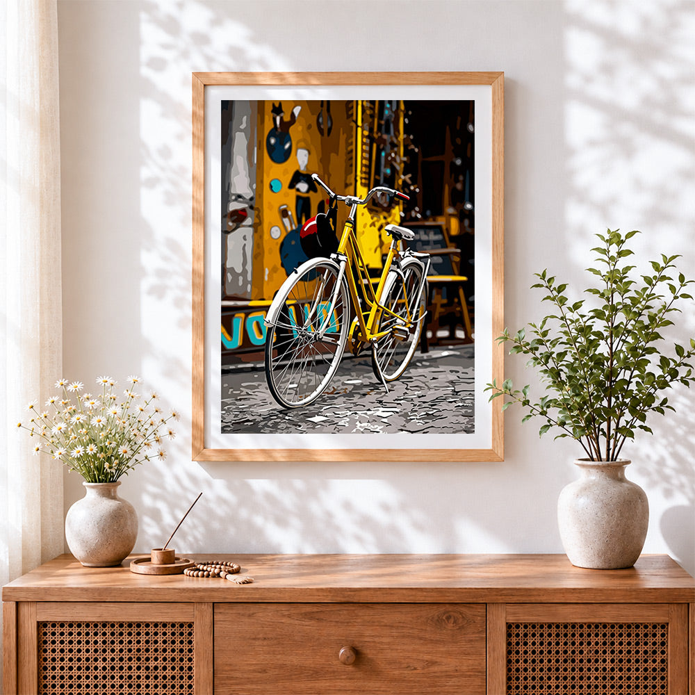 Finished yellow bicycle in the city cross stitch artwork displayed