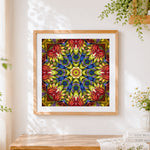 Finished yellow red and blue kaleidoscope mandala cross stitch artwork displayed