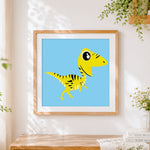 Finished yellow striped velociraptor dinosaur cross stitch artwork displayed