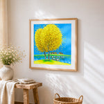 Yellow tree and lakeside village cross stitch artwork displayed on wall as home decor