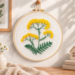 Yellow wildflower stem embroidery hoop wall art displayed as warm and cozy handmade home decor
